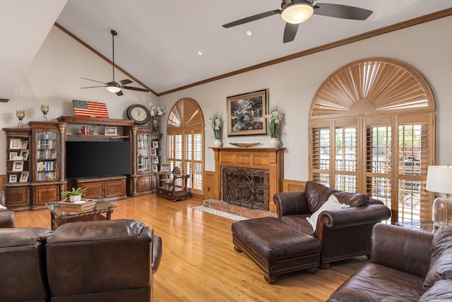 living room with ornamental molding, a brick fireplace, light hardwood / wood-style flooring, and ceiling fan