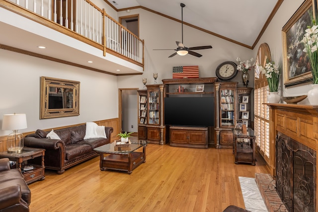 living room with ceiling fan, ornamental molding, high vaulted ceiling, and light hardwood / wood-style floors