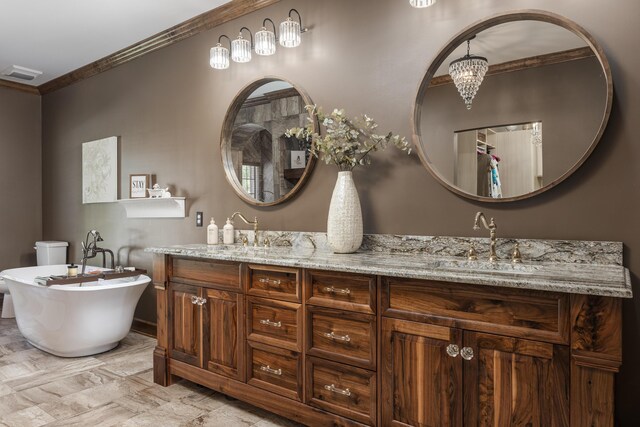 bathroom featuring ornamental molding, vanity, toilet, and a bathtub