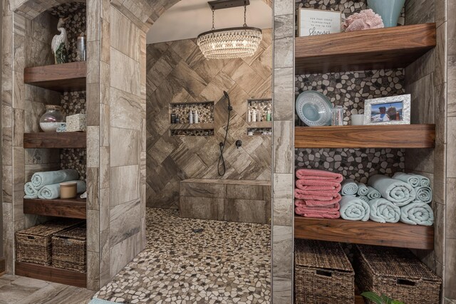 bathroom featuring a shower and a notable chandelier