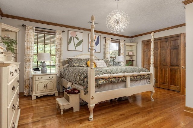 bedroom with multiple windows, hardwood / wood-style flooring, and an inviting chandelier