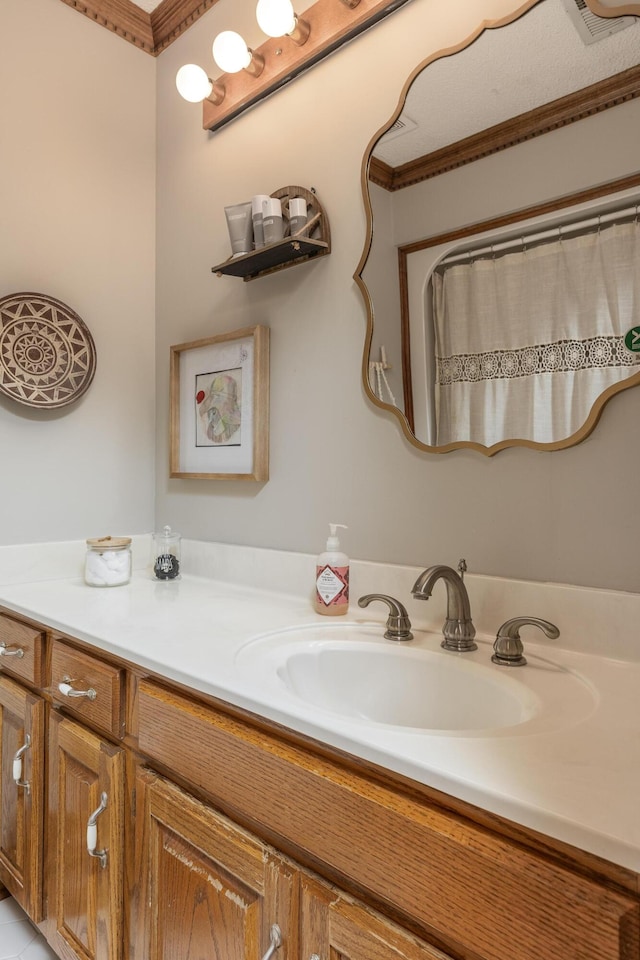 bathroom with ornamental molding and vanity