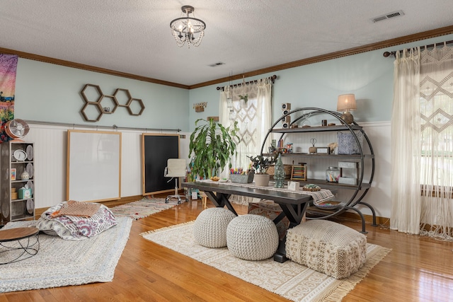 interior space with hardwood / wood-style flooring, an inviting chandelier, crown molding, and a textured ceiling