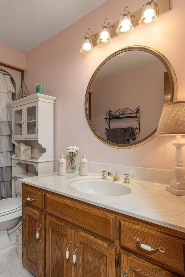 bathroom featuring a textured ceiling, vanity, toilet, and tile patterned flooring