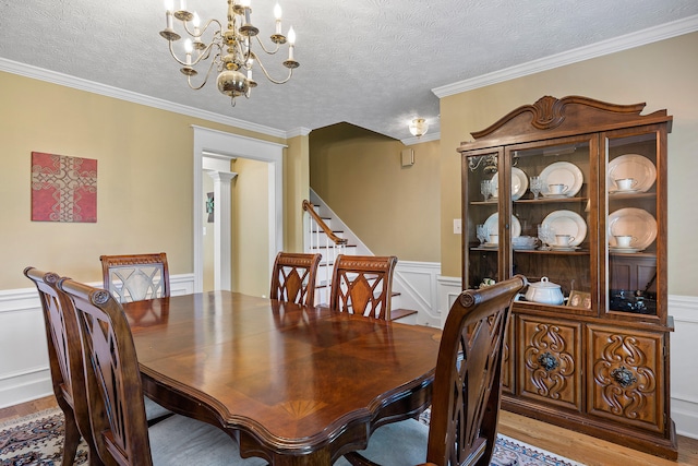 dining space featuring light wood-type flooring, a textured ceiling, and a notable chandelier