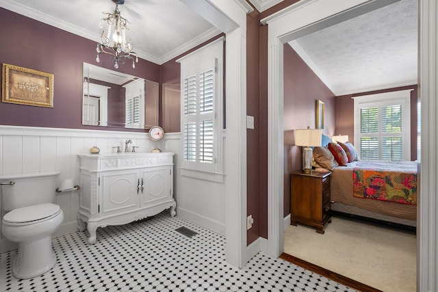 bathroom featuring toilet, ornamental molding, and a textured ceiling