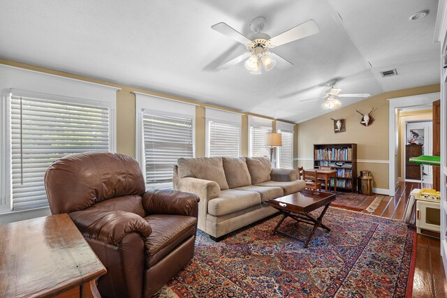 living room with a healthy amount of sunlight, ceiling fan, vaulted ceiling, and dark wood-type flooring