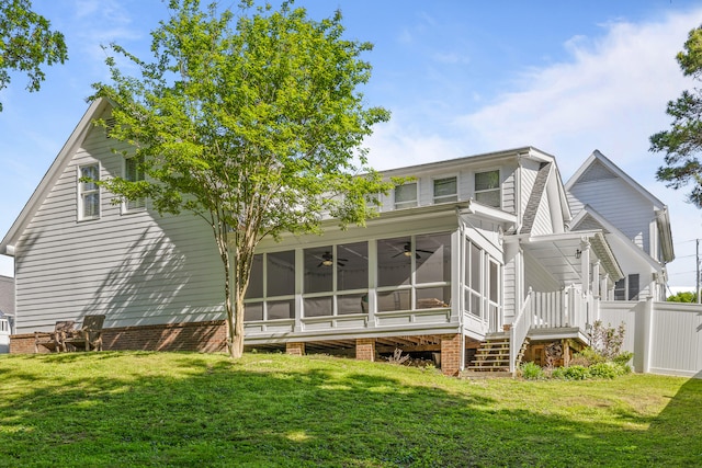 back of house with a lawn and a sunroom