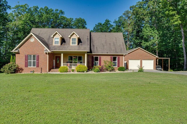 new england style home with a garage, covered porch, and a front yard