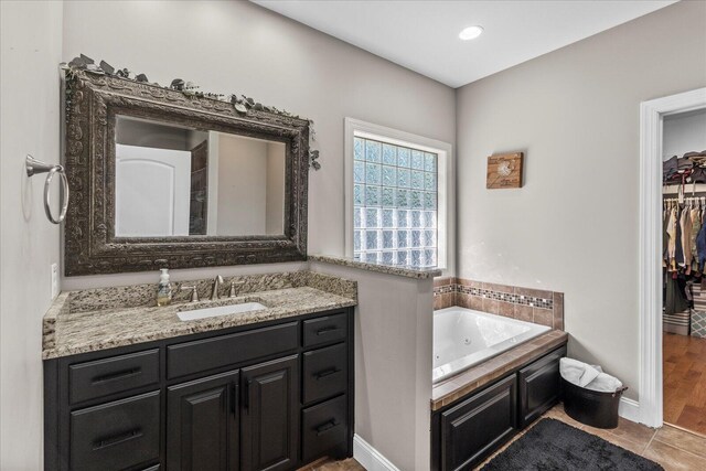 bathroom with vanity, hardwood / wood-style floors, and a bathing tub