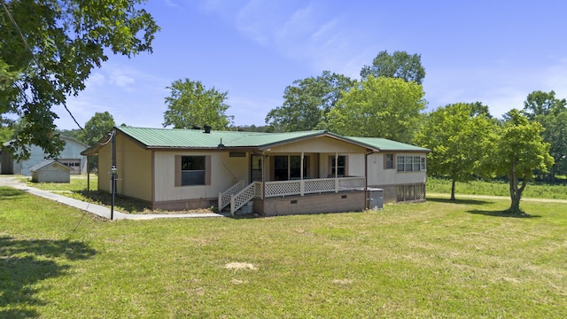 view of front of home with a front yard, a porch, crawl space, and metal roof