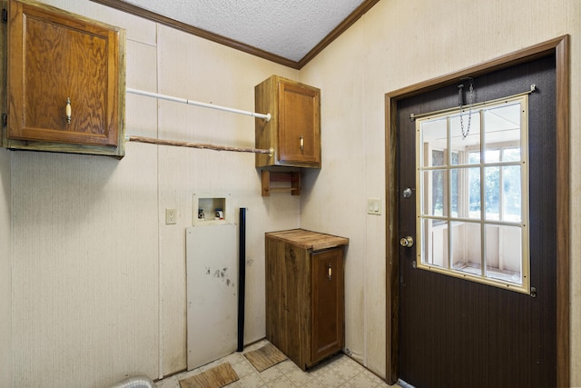 clothes washing area featuring washer hookup, ornamental molding, a textured ceiling, cabinet space, and light floors