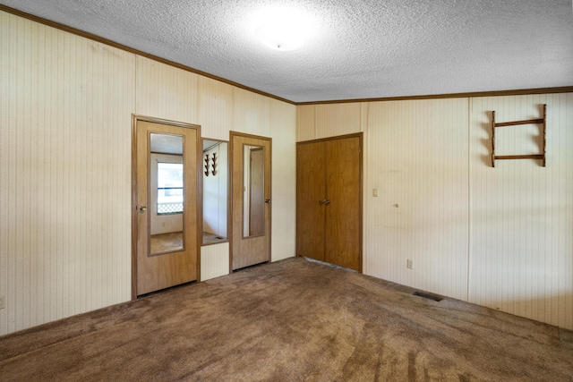 interior space featuring visible vents, a textured ceiling, crown molding, and carpet floors