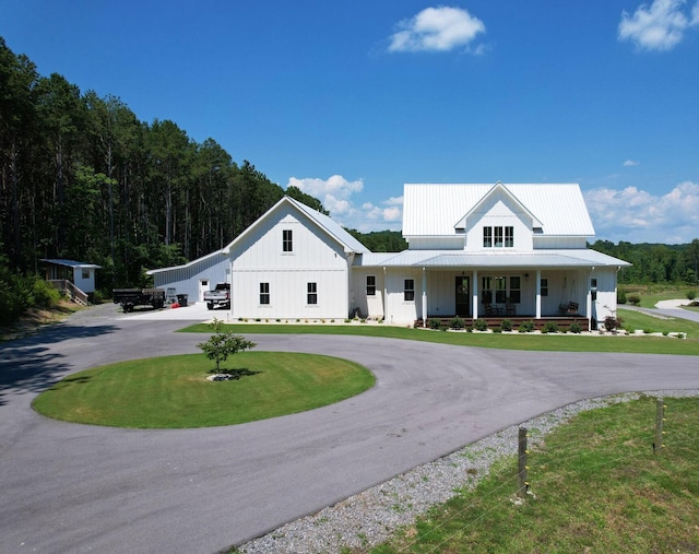 modern farmhouse style home featuring a porch and a front lawn