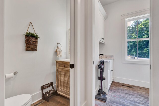 bathroom with vanity, toilet, and hardwood / wood-style floors