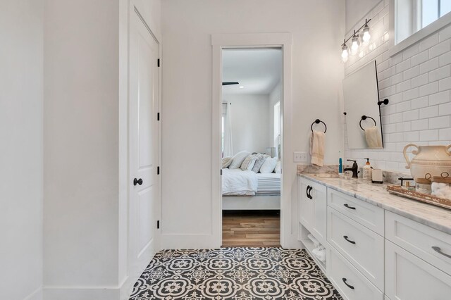 bathroom with vanity, hardwood / wood-style flooring, and decorative backsplash