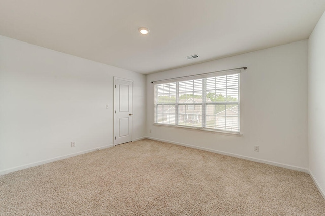 unfurnished room featuring light carpet