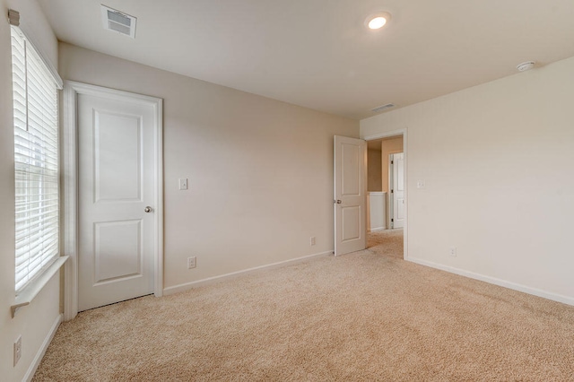 carpeted spare room featuring plenty of natural light