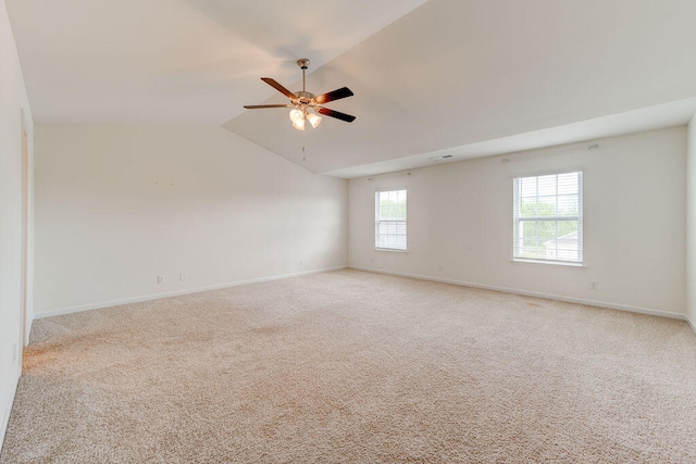 spare room featuring light colored carpet, lofted ceiling, and ceiling fan