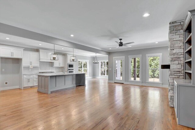 kitchen with white cabinetry, light countertops, light wood-style flooring, and a ceiling fan