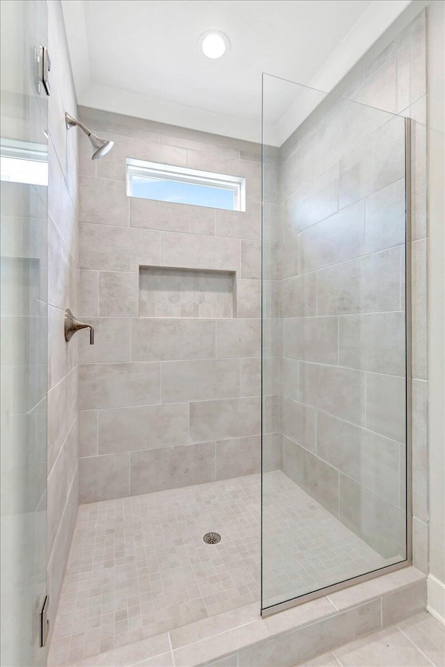 bathroom with a tile shower and tile patterned flooring