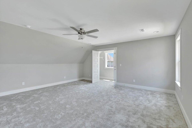 additional living space featuring visible vents, ceiling fan, carpet, baseboards, and vaulted ceiling