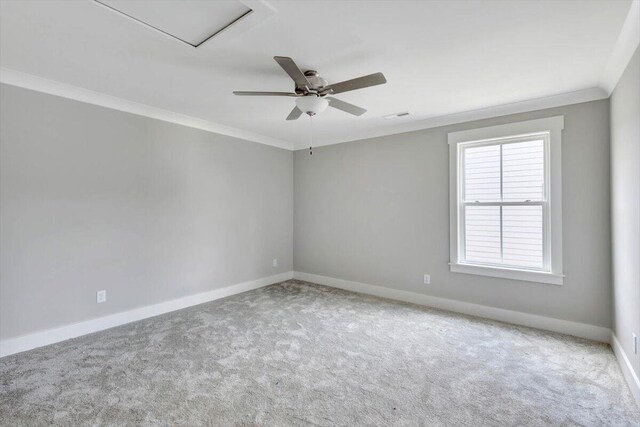 carpeted spare room with ceiling fan and crown molding