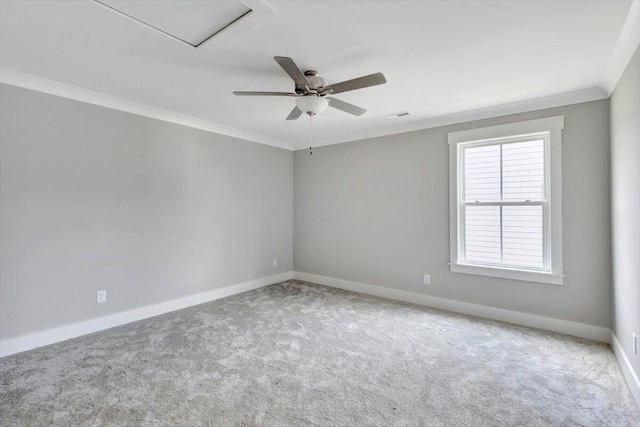 carpeted empty room with ceiling fan, visible vents, baseboards, and ornamental molding