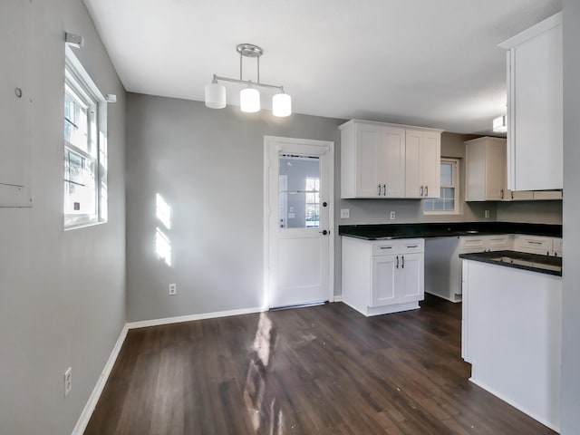 kitchen featuring white cabinets, hanging light fixtures, and dark hardwood / wood-style flooring