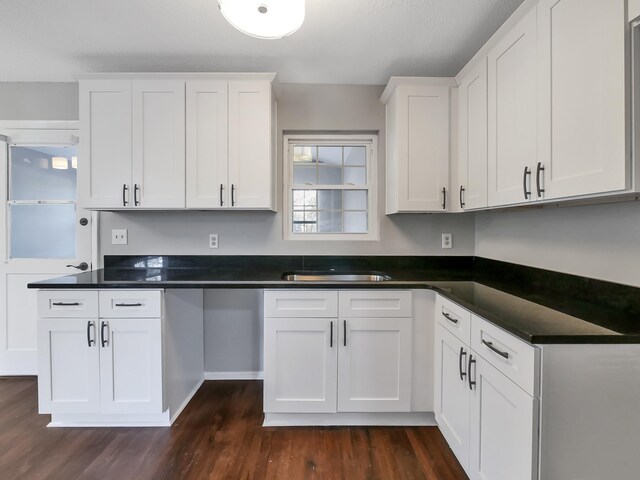 kitchen featuring dark wood-type flooring, sink, and white cabinetry