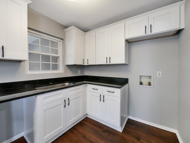 kitchen featuring dark wood-type flooring, sink, and white cabinets