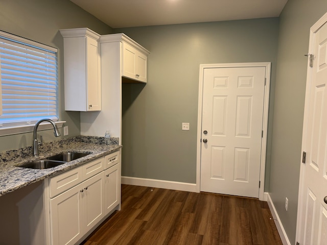 kitchen with light stone countertops, sink, dark hardwood / wood-style floors, and white cabinets