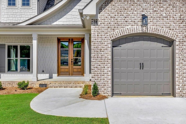 view of exterior entry featuring a garage and a porch