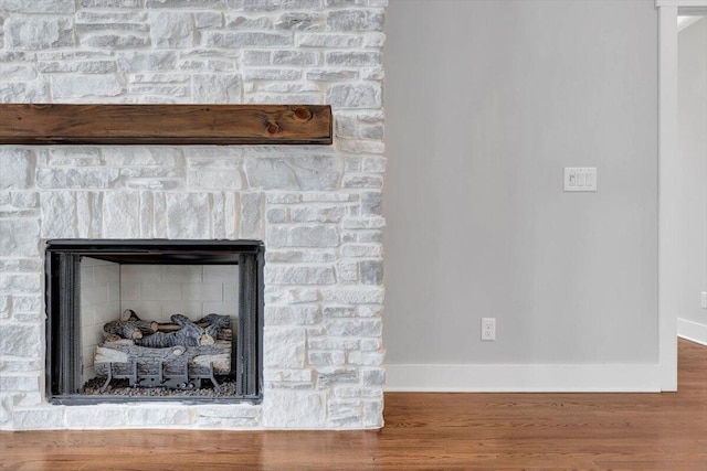 room details with a fireplace, baseboards, and wood finished floors