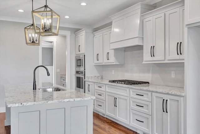 kitchen with light wood-type flooring, stainless steel appliances, sink, light stone countertops, and white cabinets