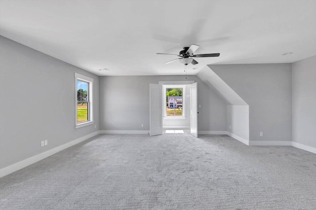 additional living space featuring plenty of natural light, baseboards, carpet floors, and ceiling fan