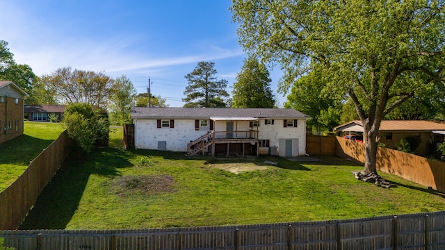 rear view of house with a yard and a wooden deck