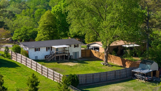 back of property featuring a deck, a lawn, and a shed