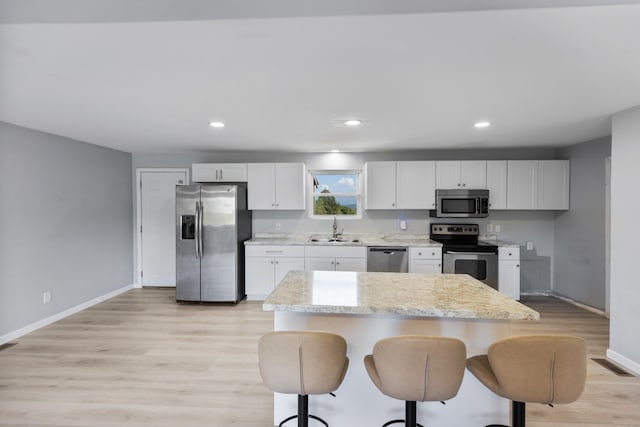 kitchen featuring stainless steel appliances, white cabinetry, and a kitchen island