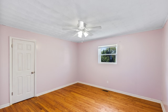 spare room featuring wood-type flooring, ornamental molding, and ceiling fan