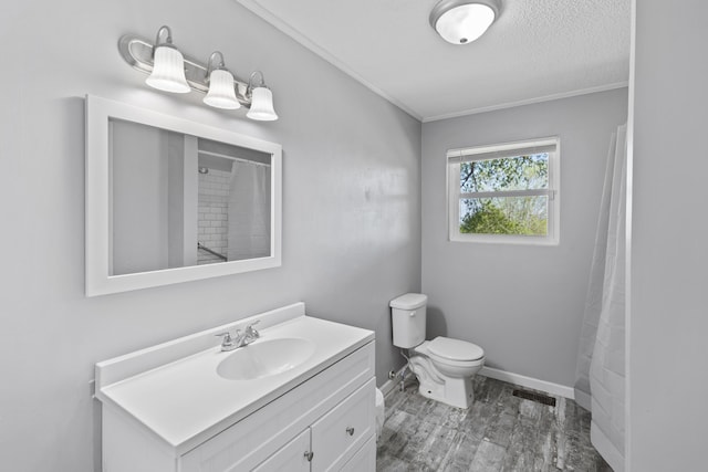 bathroom featuring a textured ceiling, hardwood / wood-style flooring, ornamental molding, vanity, and toilet