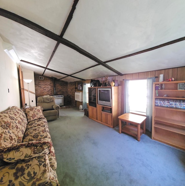 living room with beamed ceiling, a wood stove, carpet flooring, an AC wall unit, and brick wall