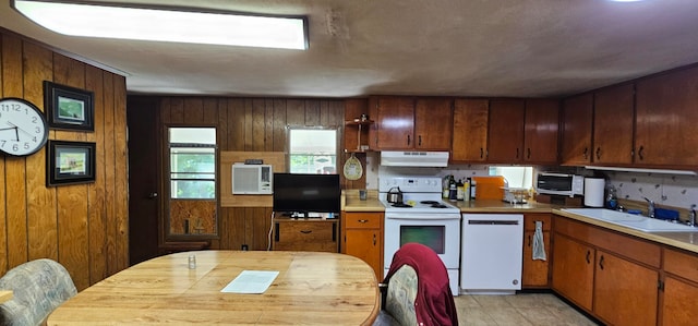 kitchen featuring wood walls, sink, and white appliances