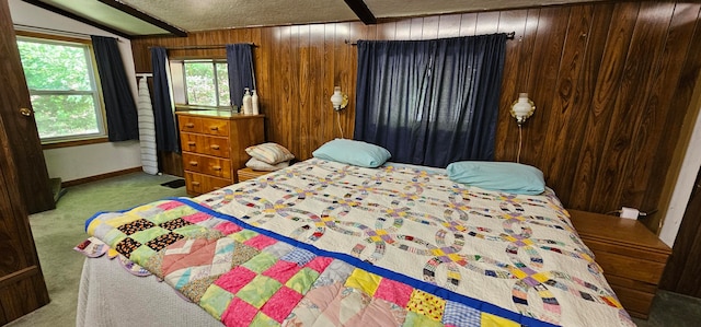 carpeted bedroom with a textured ceiling, wood walls, and beamed ceiling