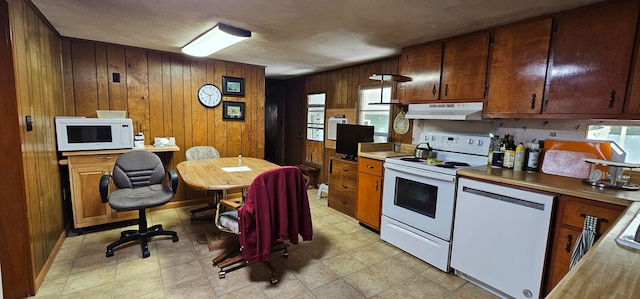 kitchen with white appliances, a wealth of natural light, and wooden walls