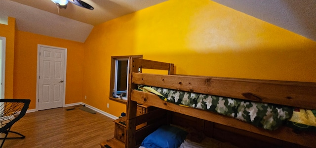 bedroom with vaulted ceiling, wood-type flooring, and ceiling fan