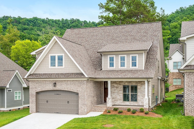 view of front facade with driveway, covered porch, a front yard, a shingled roof, and a garage