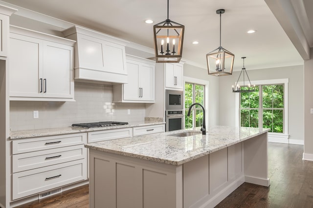 kitchen featuring pendant lighting, an island with sink, white cabinets, and dark wood-type flooring