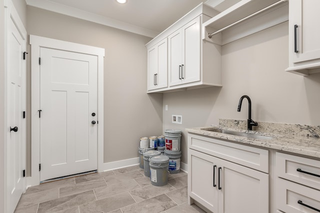 washroom with washer hookup, cabinets, crown molding, and sink