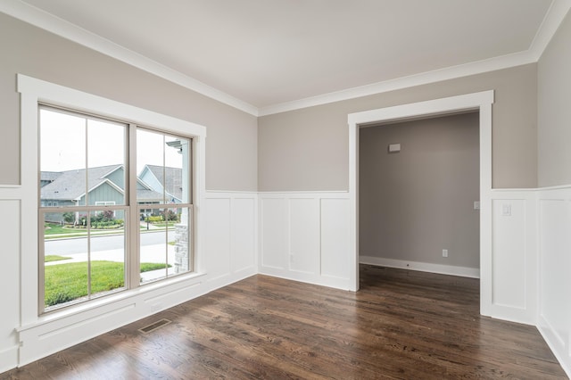 empty room with visible vents, a healthy amount of sunlight, ornamental molding, and dark wood-style flooring